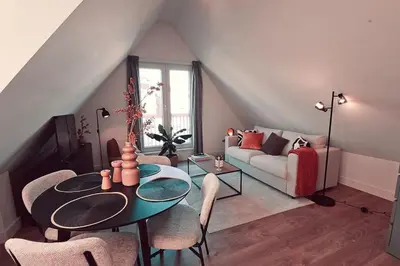 a living room with a table and a couch at Tante Bed 44 B in Voorschoten
