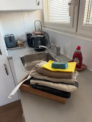 a pile of towels sitting on a counter next to a sink at Tante Bed 44 B in Voorschoten