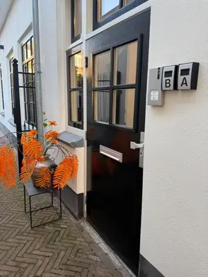 a black door to a building with a table and chairs at Tante Bed 44 B in Voorschoten
