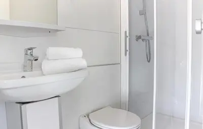 a white bathroom with a sink and a toilet at Havenlodge Lelystad in Lelystad