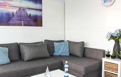 a living room with a gray couch with blue pillows at Havenlodge Lelystad in Lelystad