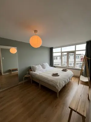 a bedroom with a large bed with two orange lights at Haarlem jaren' 30 huis Stad & Strand in Haarlem