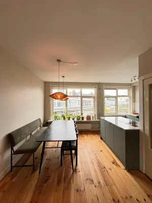 a kitchen and dining room with a table and a couch at Haarlem jaren' 30 huis Stad & Strand in Haarlem
