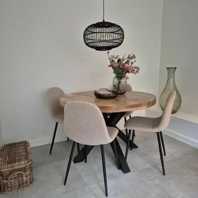 a dining room table with chairs and a vase of flowers at Het Klokkenest in Katwijk aan Zee