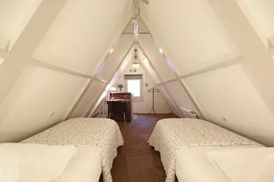 a attic room with two beds and a piano at Dok Apartments in Amsterdam