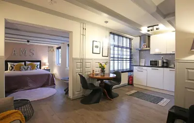 a bedroom with a bed and a table and a kitchen at Dok Apartments in Amsterdam