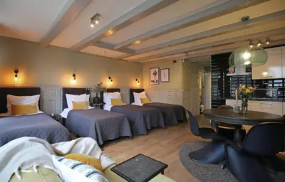 a hotel room with three beds and a table at Dok Apartments in Amsterdam