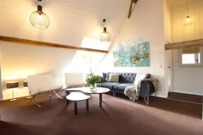 a living room with a couch and a table at Huize de Lekpoort - The Stork Loft - Loft Apartment in Vianen Center in Vianen