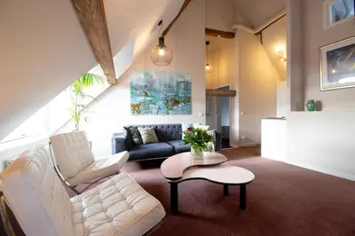 a living room with a couch and a table at Huize de Lekpoort - The Stork Loft - Loft Apartment in Vianen Center in Vianen