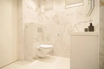 a white bathroom with a toilet and a sink at Spacious Suite at Park and Museum in Amsterdam