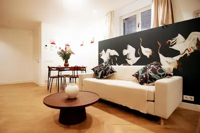 a living room with a white couch and a table at Spacious Suite at Park and Museum in Amsterdam