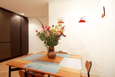a vase of flowers sitting on a wooden table at Spacious Suite at Park and Museum in Amsterdam
