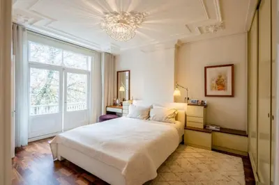 a bedroom with a large bed and a chandelier at The Elegant Amsterdam Apartment in Amsterdam