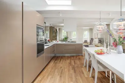 a kitchen with a long table and white cabinets at The Elegant Amsterdam Apartment in Amsterdam