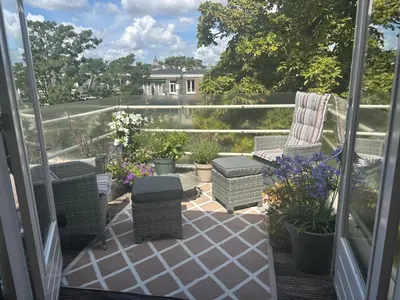 a balcony with chairs and a table and flowers at The Elegant Amsterdam Apartment in Amsterdam