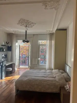 a bedroom with a large bed and two windows at The Elegant Amsterdam Apartment in Amsterdam