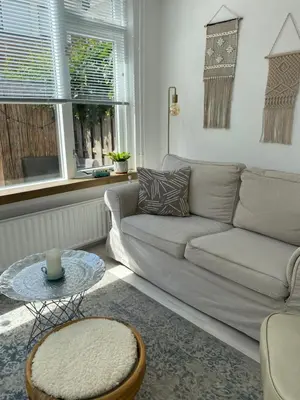 a living room with a couch and a table at Lola's Beachhouse in Noordwijk aan Zee