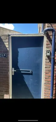 a large garage door with a metal handle on it at Lola's Beachhouse in Noordwijk aan Zee