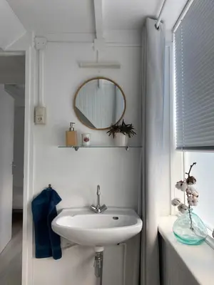 a bathroom with a sink and a mirror at Lola's Beachhouse in Noordwijk aan Zee