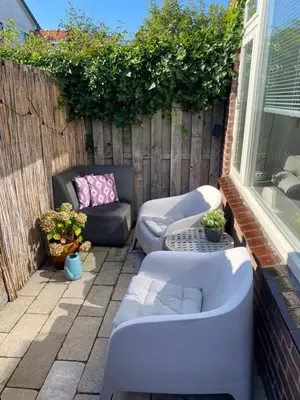 a patio with a couch and a bath tub at Lola's Beachhouse in Noordwijk aan Zee