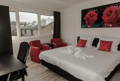 a bedroom with a bed and two red chairs at Amsterdam Soul Inn in Amsterdam