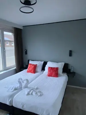 a bedroom with a large white bed with red pillows at Amsterdam Soul Inn in Amsterdam