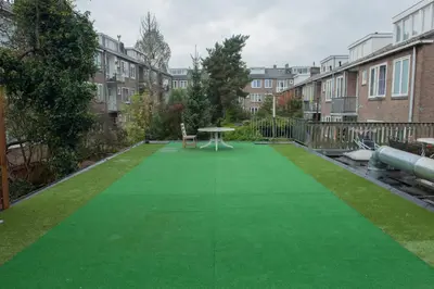 a green artificial lawn in a yard with buildings at Amsterdam Soul Inn in Amsterdam