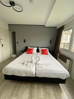 a bedroom with a large white bed with red pillows at Amsterdam Soul Inn in Amsterdam