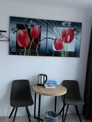 a table with two chairs and a painting of red flowers at Amsterdam Soul Inn in Amsterdam