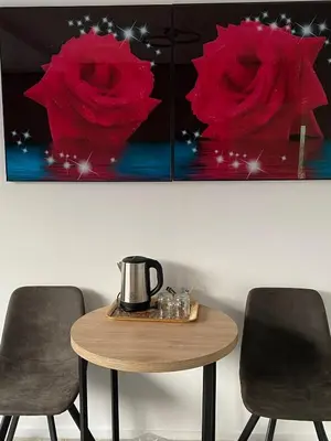 a table with two red roses paintings on the wall at Amsterdam Soul Inn in Amsterdam