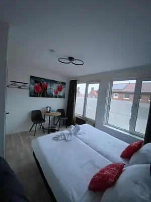 a bedroom with a large white bed and windows at Amsterdam Soul Inn in Amsterdam