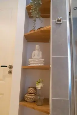 a shelf with a statue of a buddha on it at Julia's Holidayhome in Egmond-Binnen