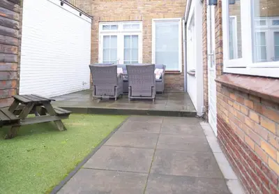 a patio with chairs and a table and a picnic table at Julia's Holidayhome in Egmond-Binnen