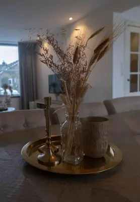 a tray with a vase of flowers and a coffee cup at Julia's Holidayhome in Egmond-Binnen