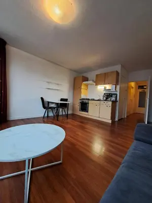 a living room with a table and a kitchen at Apartments, 20 minutes from Amsterdam, Full service objectcode UM46 in Uitgeest