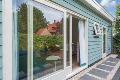 a sliding glass door on a house with a patio at Blue Oasis Cottage - Free Parking in Zandvoort