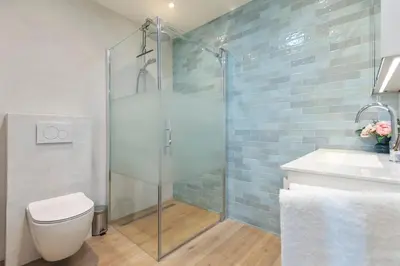 a bathroom with a shower and a toilet and a sink at Blue Oasis Cottage - Free Parking in Zandvoort