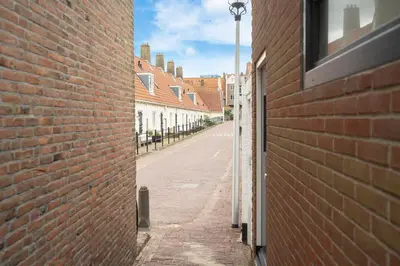 an empty alley with a brick wall and a street at Skua Escape in Zandvoort
