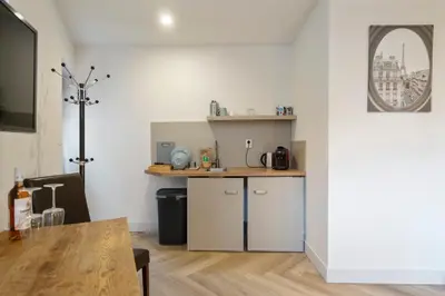 a kitchen with white cabinets and a table in a room at Skua Escape in Zandvoort