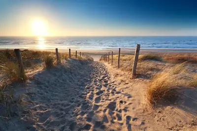 a sandy path to the beach with the ocean at Vakantiehuis de Creutz in Beverwijk