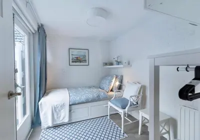 a small bedroom with a bed and a chair at Huisje Bloemenzee in Noordwijkerhout