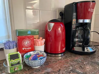 a red coffee maker sitting on a counter next to a mixer at Charming villa,central location,train and bus nearby in Soest