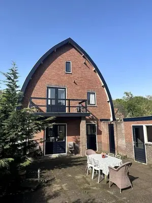 a house with a table and chairs in front of it at Charming villa,central location,train and bus nearby in Soest