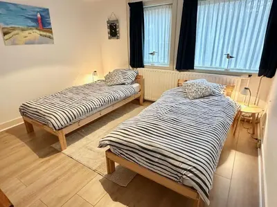 two beds sitting in a room with windows at Charming villa,central location,train and bus nearby in Soest