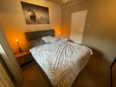 a bedroom with a bed and a table with two candles at Luxe appartement bij Zuidas met tuin en buitendouche in Amsterdam