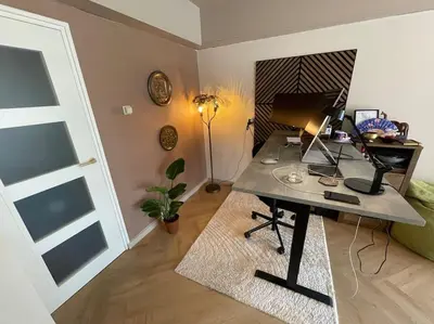 a desk with a computer on it in a room at Luxe appartement bij Zuidas met tuin en buitendouche in Amsterdam