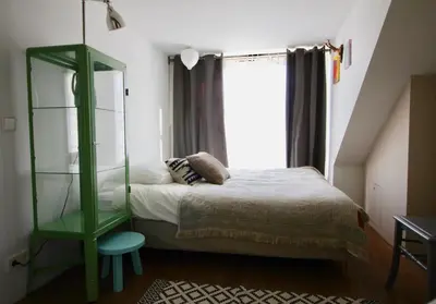 a bedroom with a bed and a green shelf at Private room in Design House near Amsterdam in Halfweg