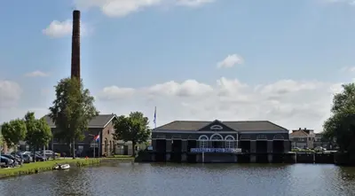 a building on the water next to a river at Private room in Design House near Amsterdam in Halfweg