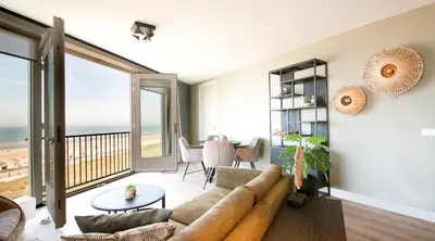 a living room with a couch and a table at Lido Zeezicht appartementen in Egmond aan Zee