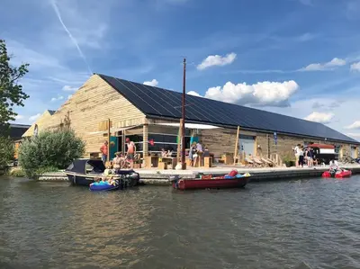 a building with people on boats on the water at Trek-in in IJsselstein